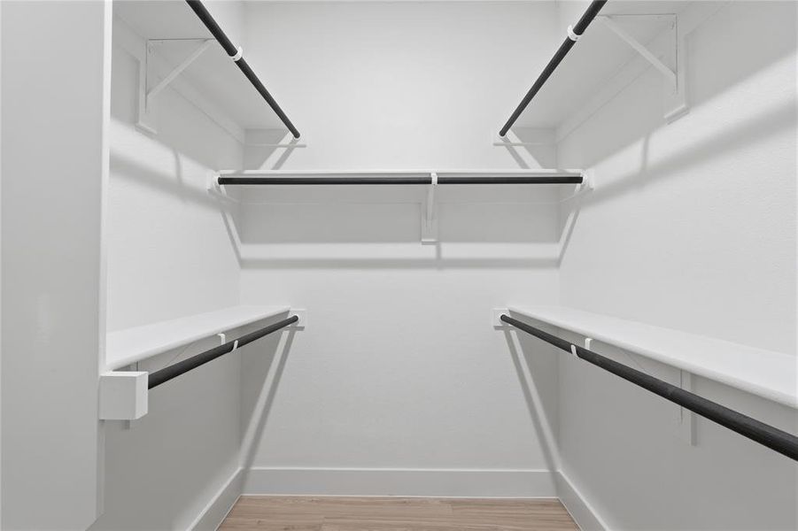 Walk in closet featuring light wood-type flooring Walk in closet featuring light wood-type flooring