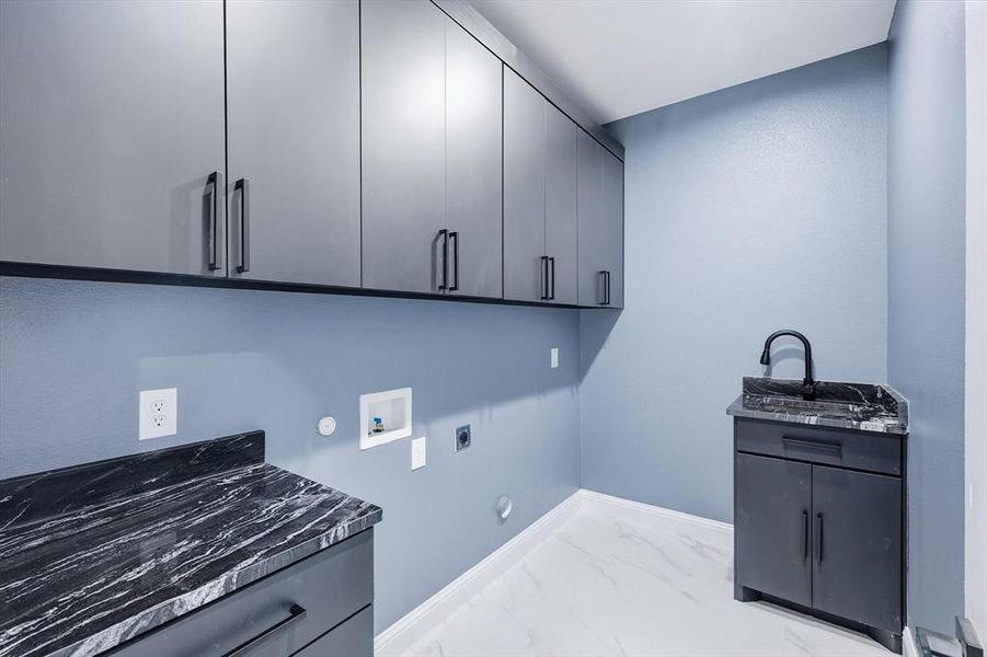Washroom featuring hookup for a washing machine, light marble finish floors, hookup for a gas dryer, hookup for an electric dryer, and cabinet space