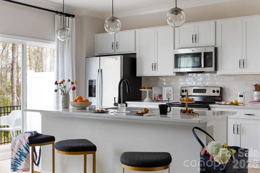 Kitchen with white cabinets and white quartz countertops