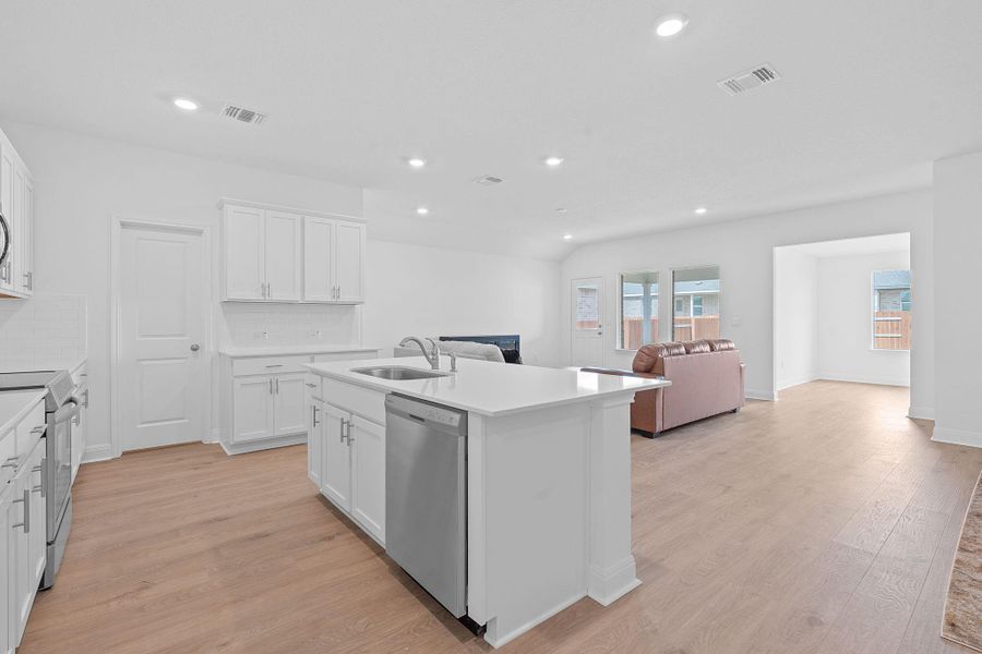Kitchen featuring light wood-style flooring, white cabinets, appliances with stainless steel finishes, an island with sink, and recessed lighting Kitchen featuring light wood-style flooring, white cabinets, appliances with stainless steel finishes, an island with sink, and recessed lighting