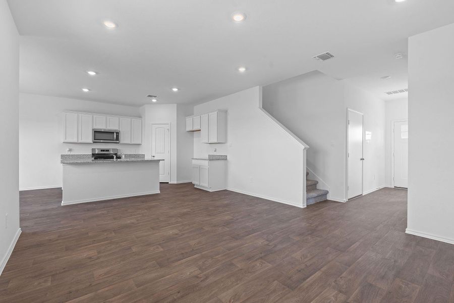 Unfurnished living room with recessed lighting, dark wood-style flooring, and stairway Unfurnished living room with recessed lighting, dark wood-style flooring, and stairway