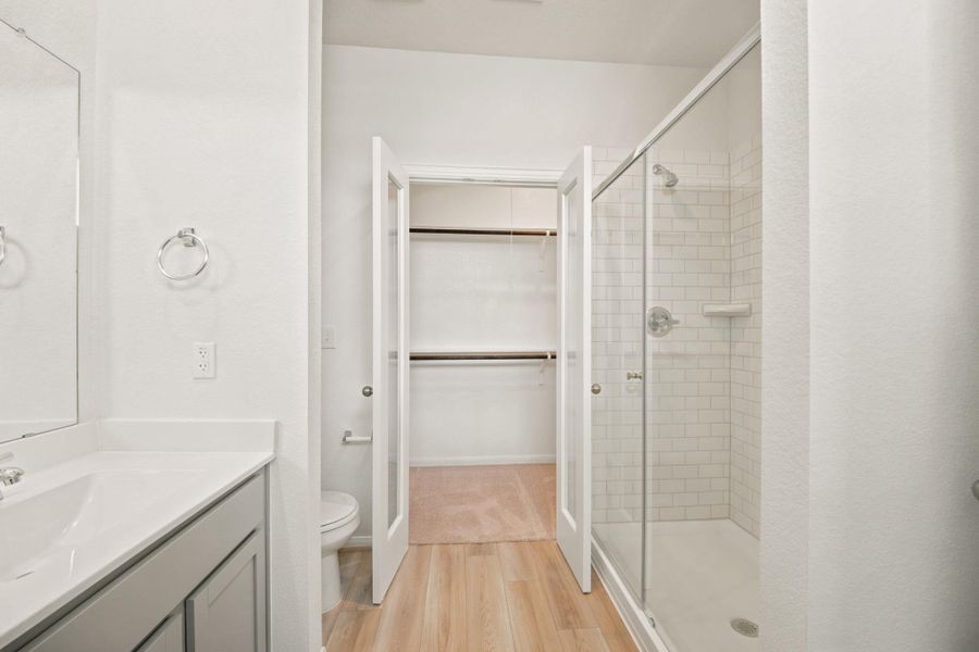 Clean lines and classic tile define this modern bathroom with an integrated walk-in closet.