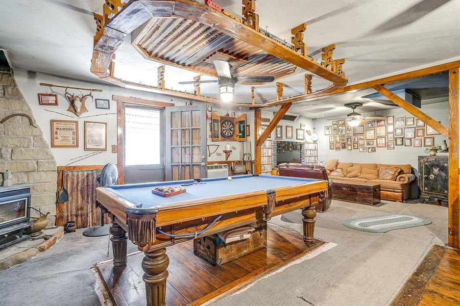 Recreation room featuring a wood stove, billiards, ceiling fan, and carpet floors Recreation room featuring a wood stove, billiards, ceiling fan, and carpet floors