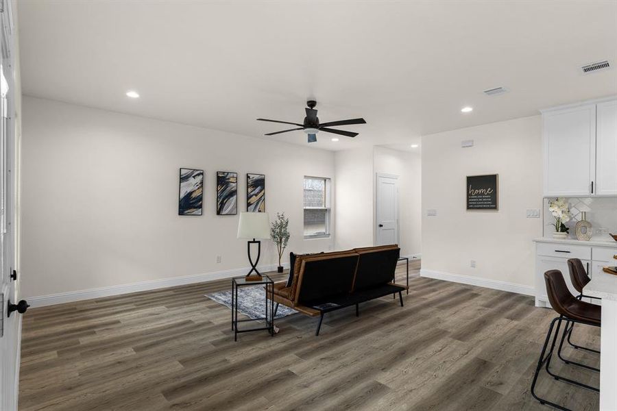 Living room featuring ceiling fan and dark hardwood / wood-style floors