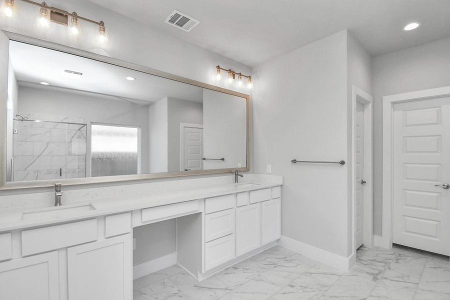 Escape to a spa-like oasis in this primary bathroom. Enjoy a walk-in shower with tile surround, a separate garden tub with custom detailing, and an elegant vanity featuring light countertops, modern hardware, and beautiful vanity lights. Experience luxury and relaxation in every detail.