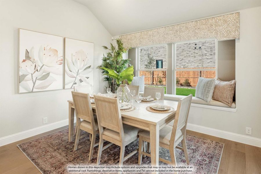 Dining room with wood table, six chairs, window seat, vaulted ceiling, and hardwood floors