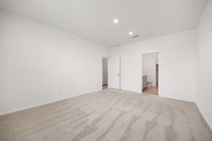The spacious first-floor primary suite offers a private retreat with plenty of room for a king-sized bed and additional furnishings.