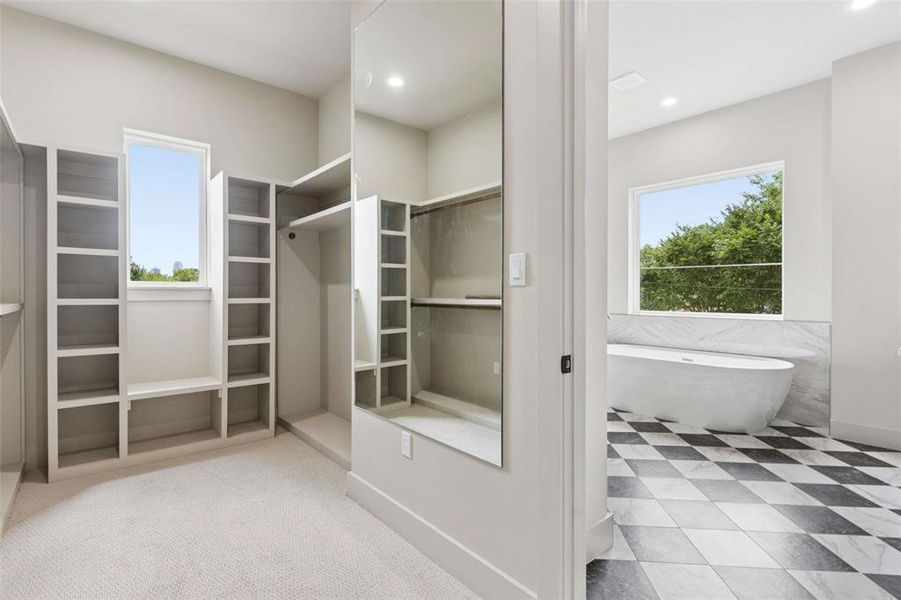 This spacious and elegantly designed primary bedroom walk-in closet features custom built-in storage shelving, sophisticated organization systems, and ample floor space to accommodate a comprehensive wardrobe with ease. This spacious and elegantly designed primary bedroom walk-in closet features custom built-in storage shelving, sophisticated organization systems, and ample floor space to accommodate a comprehensive wardrobe with ease.
