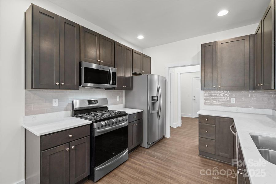 Kitchen features quartz countertops, gas stove, and stainless steel appliances. Kitchen features quartz countertops, gas stove, and stainless steel appliances.