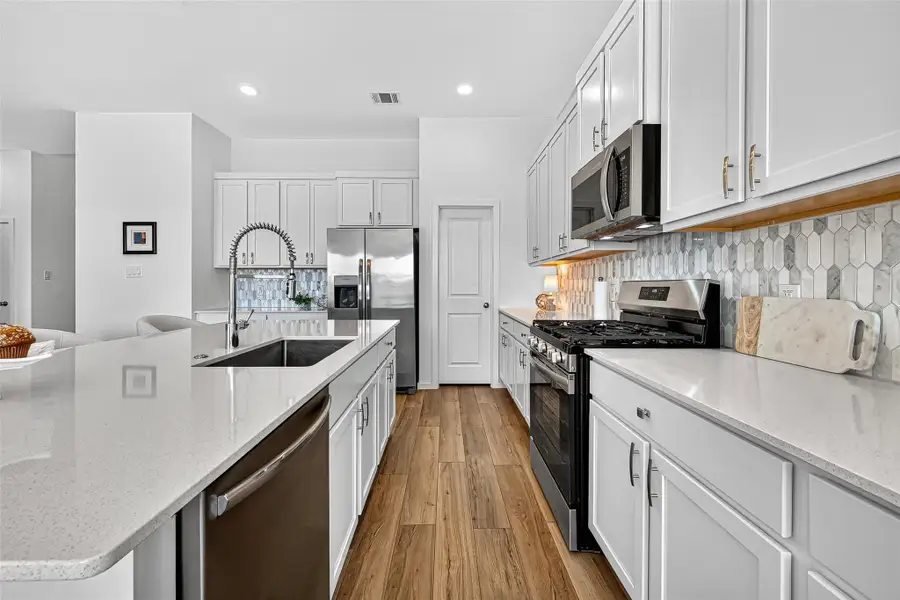 Experience culinary delight in a spacious kitchen featuring a large island and premium gas appliances. Experience culinary delight in a spacious kitchen featuring a large island and premium gas appliances.