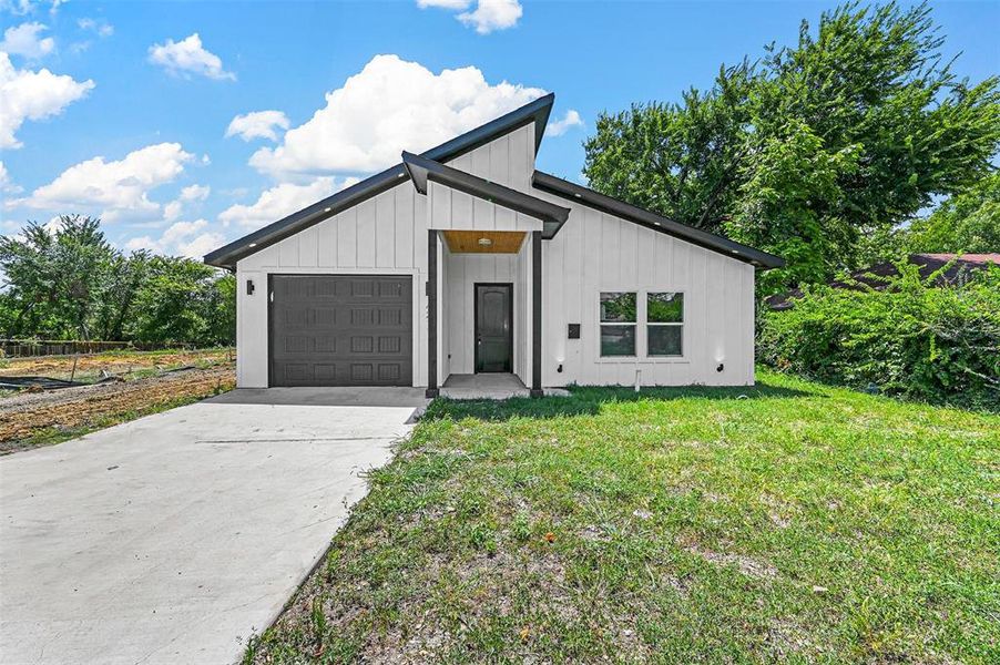 Modern farmhouse style home with a garage and a front lawn