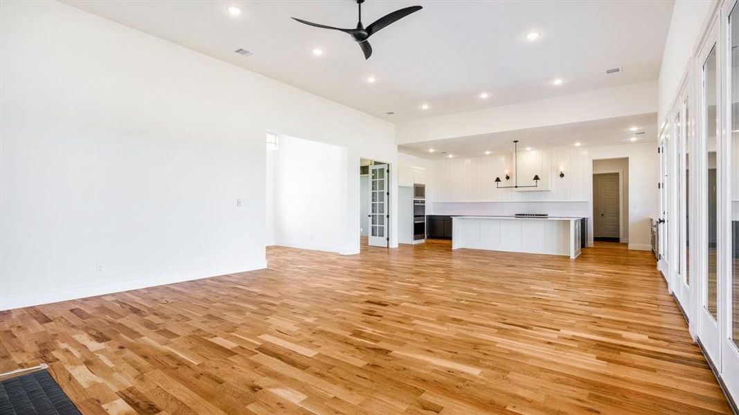 Unfurnished living room with ceiling fan and light hardwood / wood-style floors