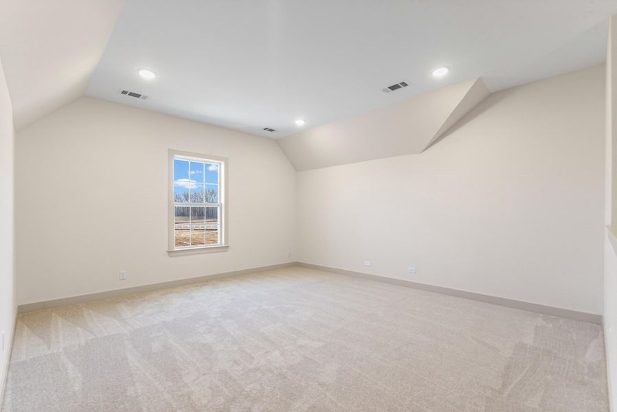 Additional living space featuring light carpet and recessed lighting
