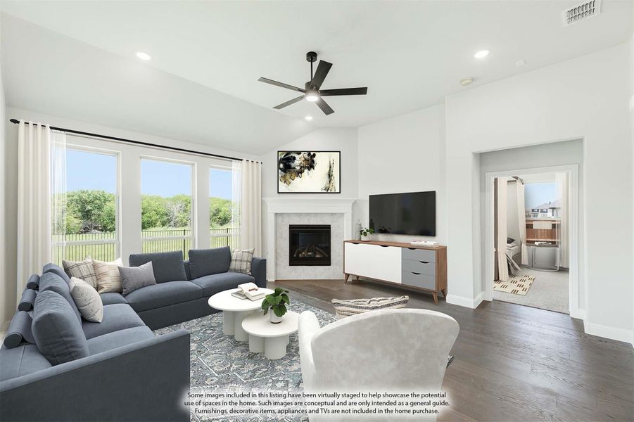 Living room with vaulted ceiling, ceiling fan, fireplace, hardwood floors, and large windows with backyard view Living room with vaulted ceiling, ceiling fan, fireplace, hardwood floors, and large windows with backyard view