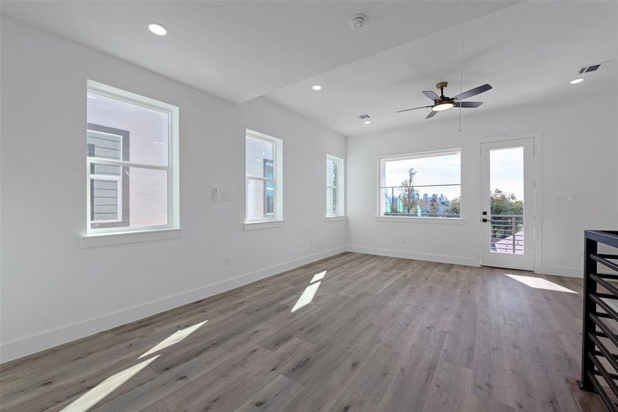 Another view of the large flex space and the balcony with views of downtown Houston.