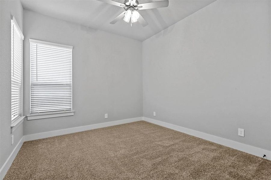 Carpeted spare room with ceiling fan