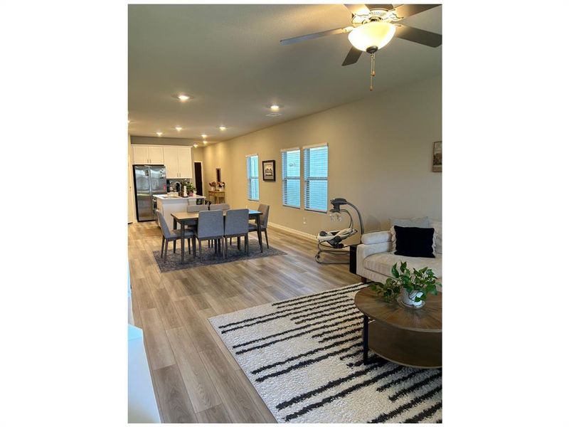 Living room featuring ceiling fan and light hardwood / wood-style floors