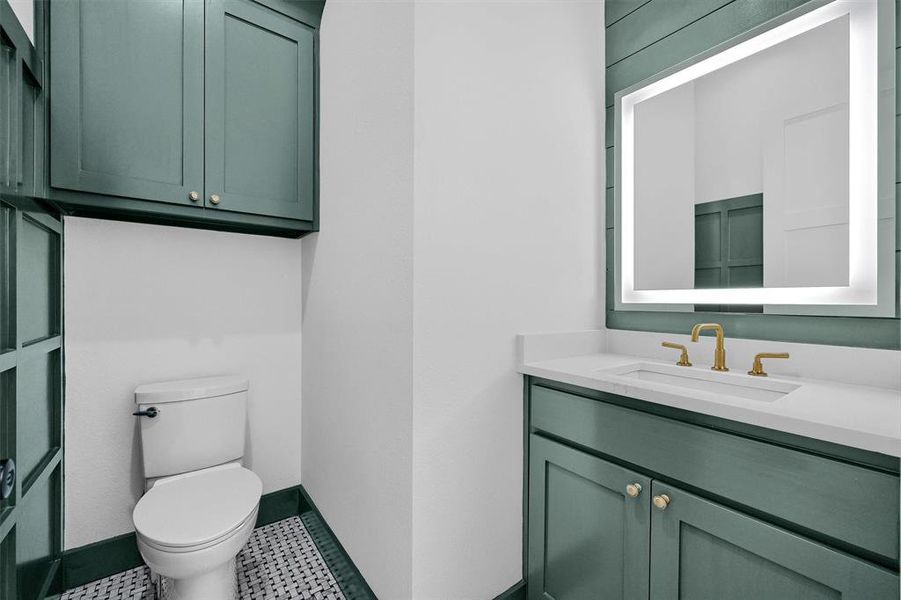 Bathroom featuring vanity, toilet, and tile patterned flooring