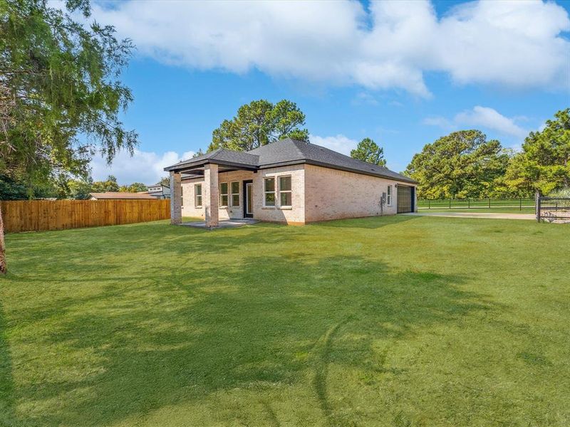 Back of house with brick siding, a patio area, and a garage