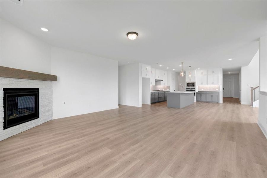 Spacious open-concept living area featuring light wood-finish flooring