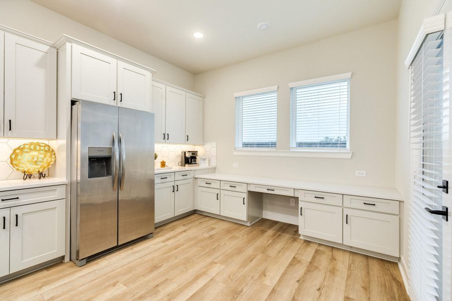 Adjacent to the stainless steel refrigerator, which can stay with the home, is additional counter space that is ideal for a coffee, tea, or wine bar. The command center is a great area to work on your favorite recipes, crafts, homework, or can serve as an entertainment buffet during a gathering.