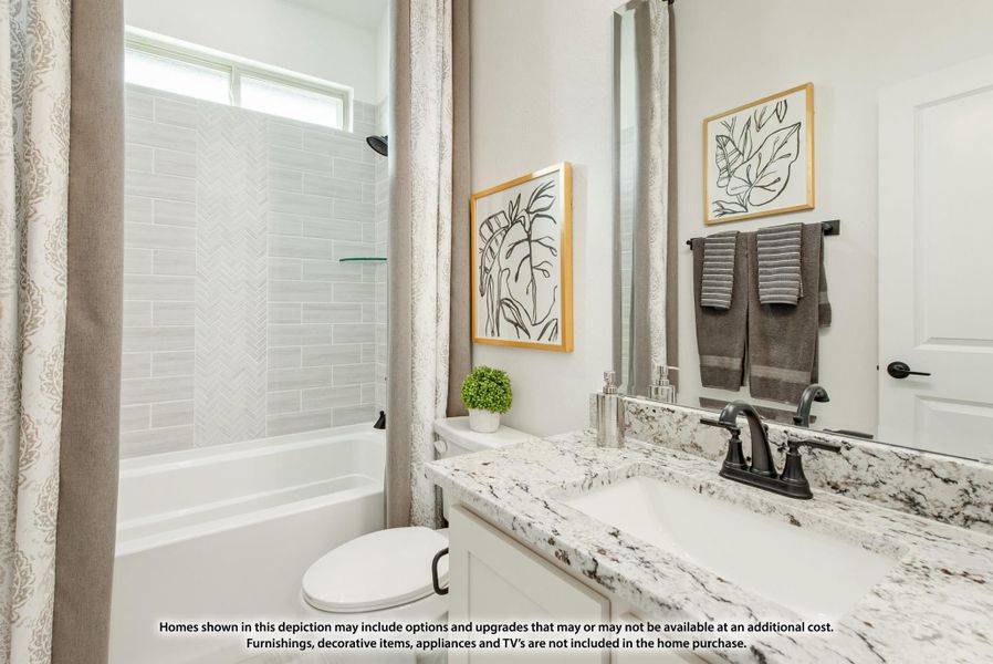Bathroom with granite countertop vanity, tub and shower with herringbone tile, and large mirror