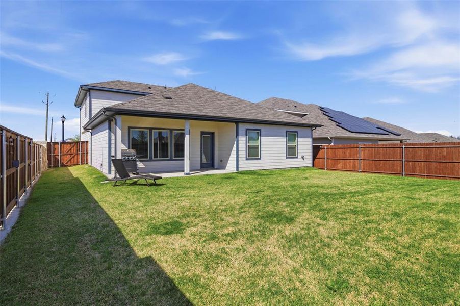 Rear view of house featuring a patio area, a fenced backyard, and roof with shingles Rear view of house featuring a patio area, a fenced backyard, and roof with shingles