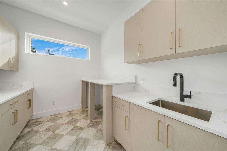 Laundry room with a sink and baseboards Laundry room with a sink and baseboards