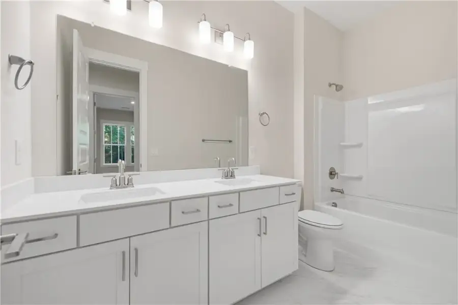 A spacious double vanity and tile flooring define
