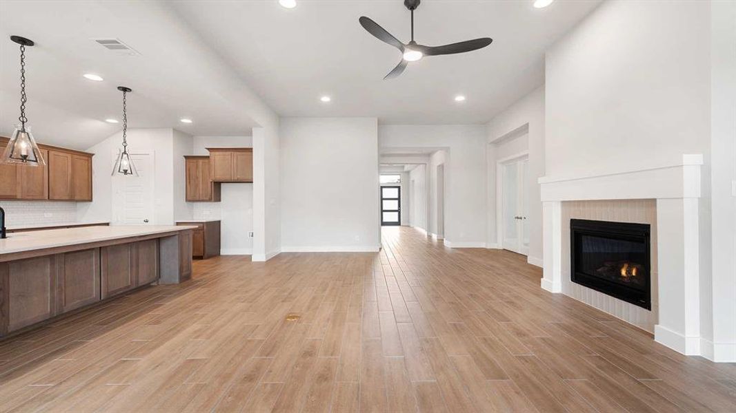 Unfurnished living room with light hardwood / wood-style floors and ceiling fan