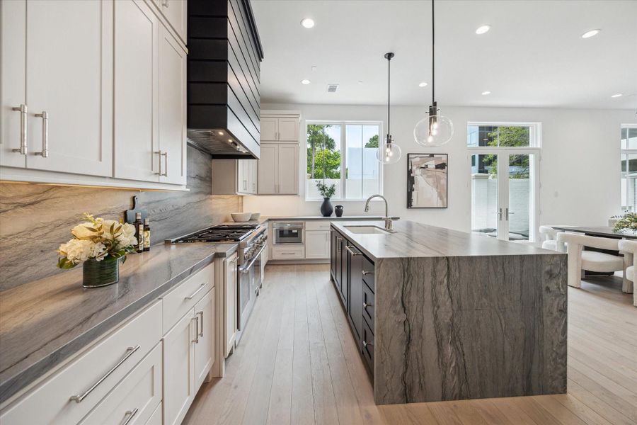 The kitchen showcases a premium Thermador appliance package, which includes a 48” Pro Harmony gas range, a 24” built-in MicroDrawer microwave, a 24” custom panel dishwasher, a 30” custom panel fresh food refrigerator, and 30” freezer columns. The kitchen showcases a premium Thermador appliance package, which includes a 48” Pro Harmony gas range, a 24” built-in MicroDrawer microwave, a 24” custom panel dishwasher, a 30” custom panel fresh food refrigerator, and 30” freezer columns.