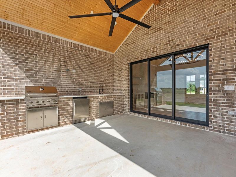 Covered patio with outdoor kitchen, prewire for cameras and tv, ceiling fan, and full outdoor bathroom. The stunner is the sliding doors!