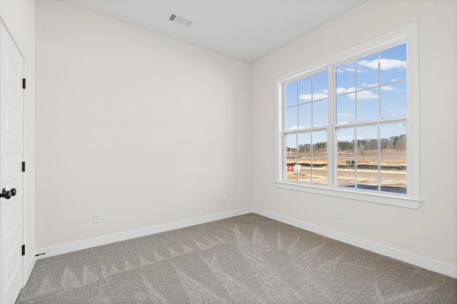 Spare room with carpet flooring and baseboards Spare room with carpet flooring and baseboards