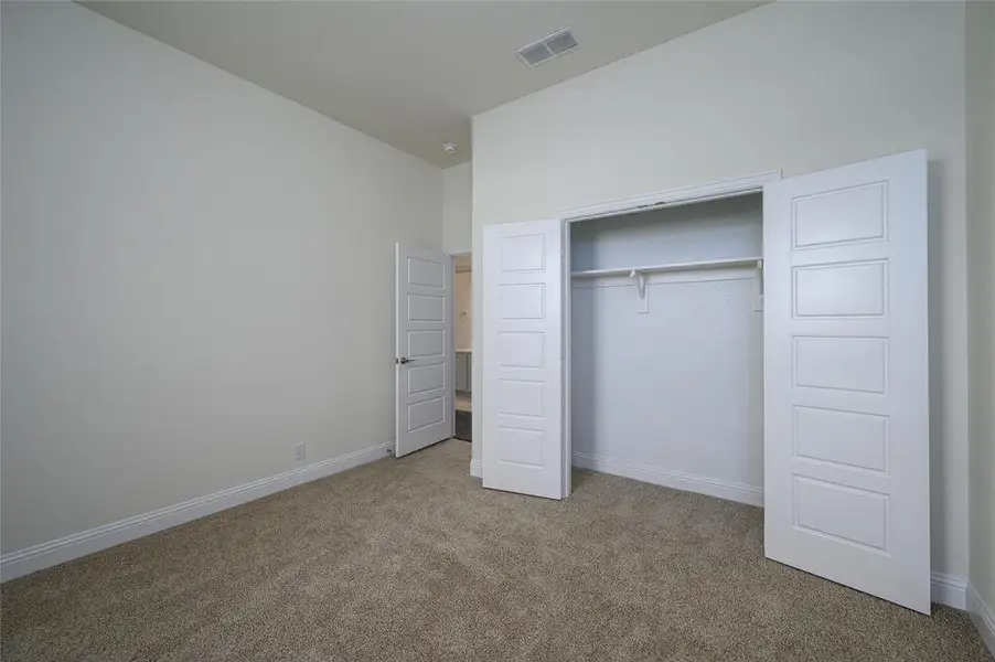 Unfurnished bedroom featuring carpet and a closet