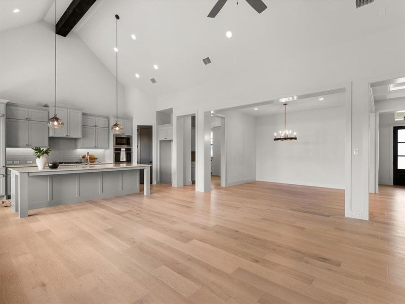 Unfurnished living room featuring high vaulted ceiling, light wood-style floors, recessed lighting, beam ceiling, and ceiling fan Unfurnished living room featuring high vaulted ceiling, light wood-style floors, recessed lighting, beam ceiling, and ceiling fan