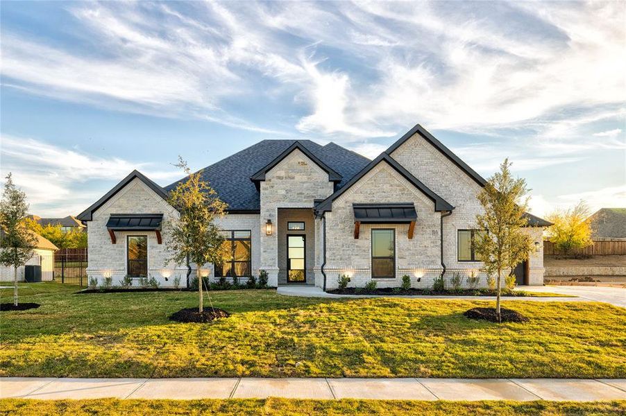 French country inspired facade featuring a front yard