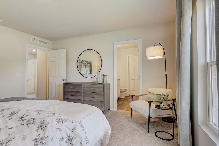 A bedroom with a bed and a table.