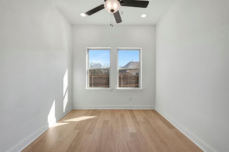 Empty room with a ceiling fan, light wood-type flooring, and recessed lighting Empty room with a ceiling fan, light wood-type flooring, and recessed lighting