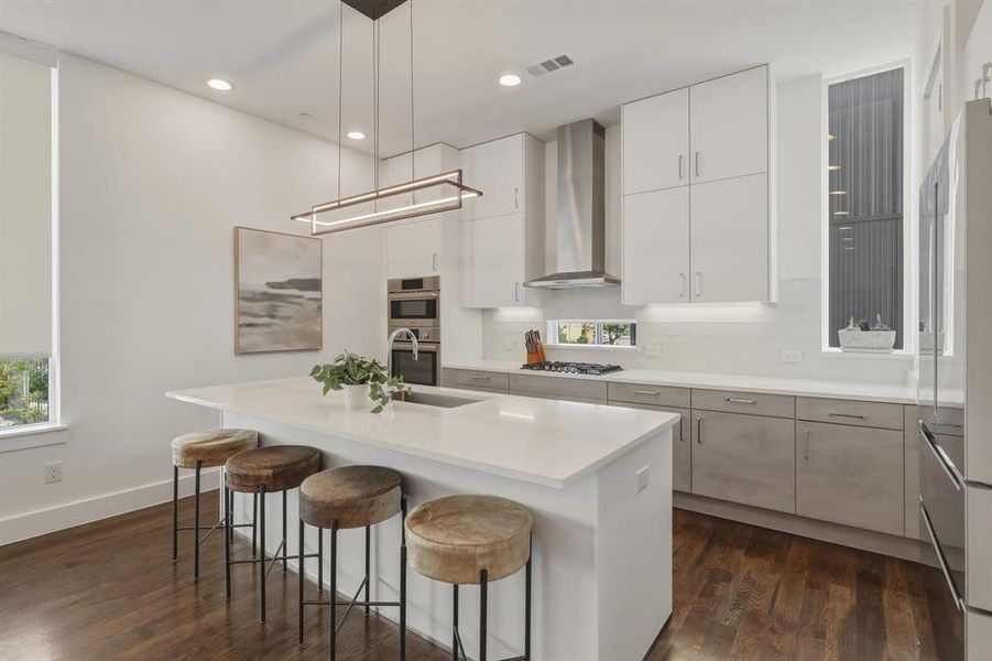 Kitchen featuring a breakfast bar area, white cabinets, dark wood finished floors, and stainless steel appliances