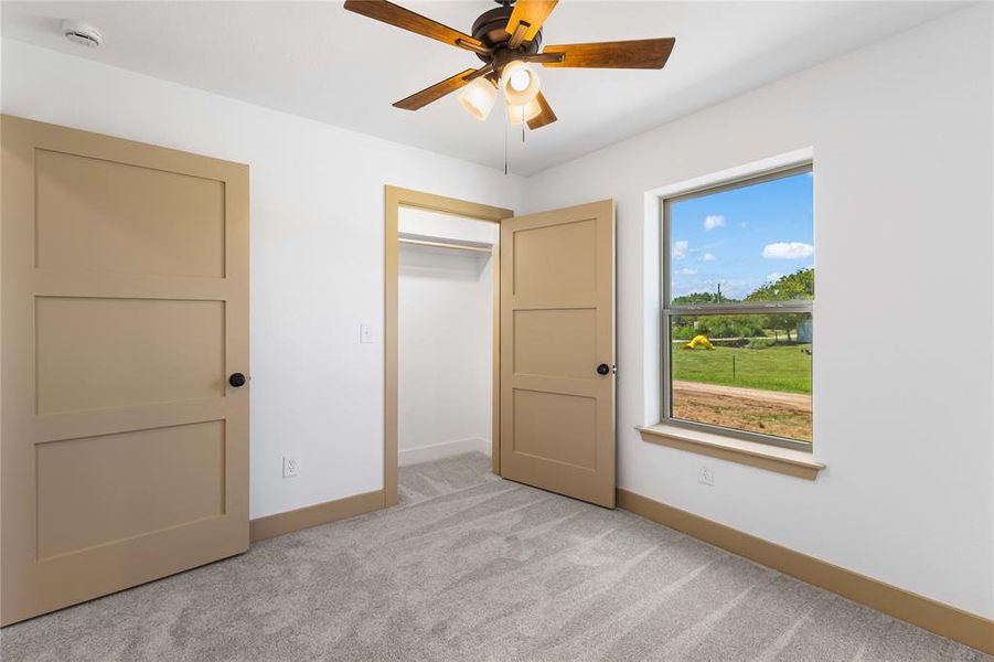 Unfurnished bedroom featuring light colored carpet and a ceiling fan
