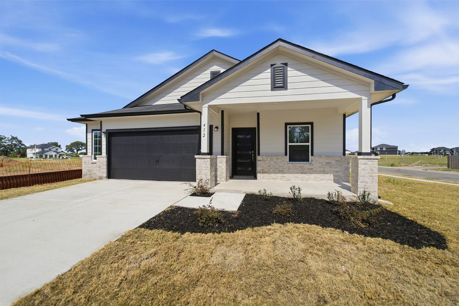 Front exterior of a new home in Paramount, Kyle, TX, highlighting curb appeal (Image 2).