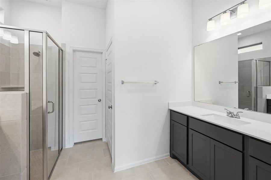 Spacious modern bathroom featuring a sleek glass-enclosed shower, elegant double vanity with ample storage, and bright lighting for a refreshing atmosphere.