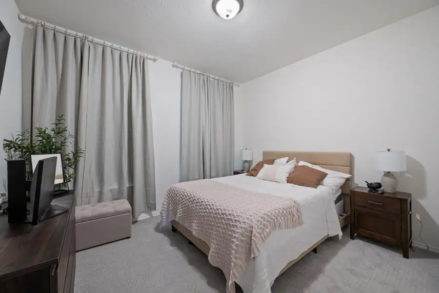 Bedroom featuring carpet floors and a textured ceiling Bedroom featuring carpet floors and a textured ceiling
