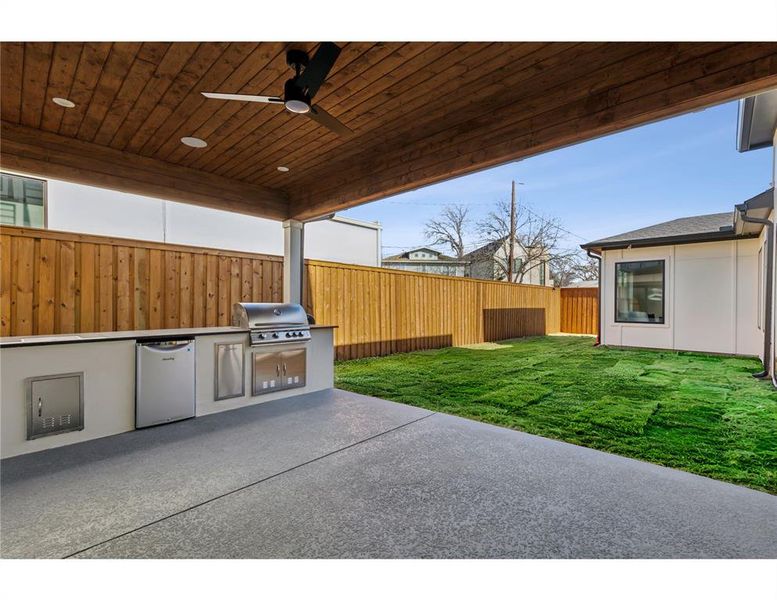 View of patio with ceiling fan and area for grilling