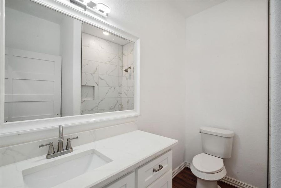 Bathroom with vanity, toilet, and tiled shower