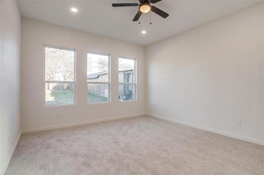 Carpeted empty room featuring ceiling fan