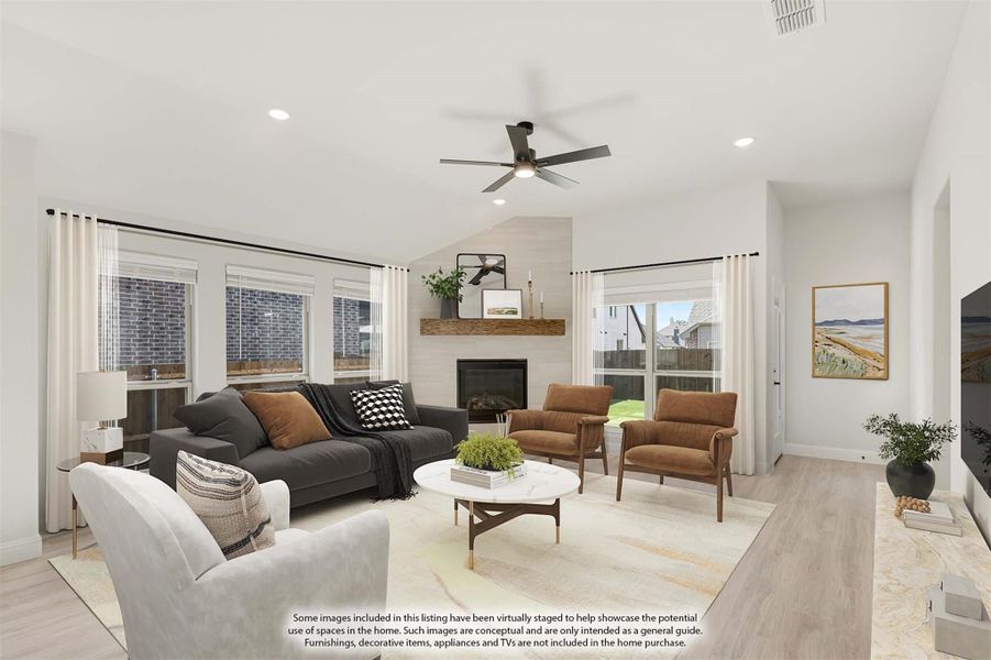 Living room with vaulted ceiling, tile fireplace, ceiling fan, and light wood floors