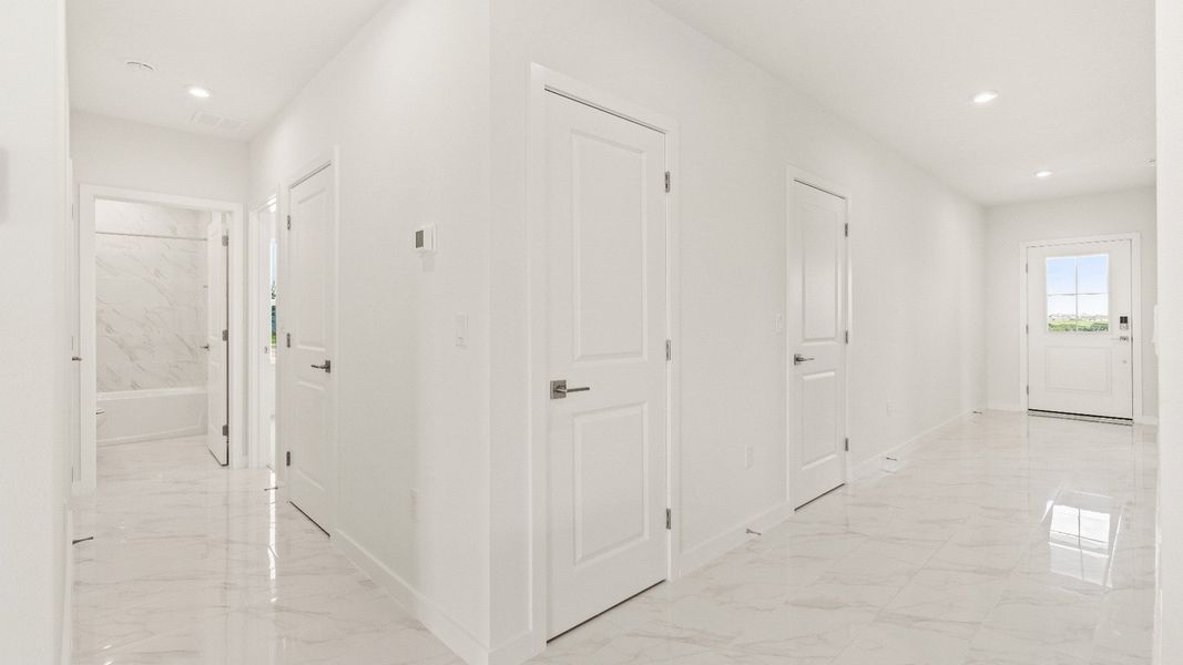 Spacious hallway with marble-style tile flooring and modern white doors in the Castaway model