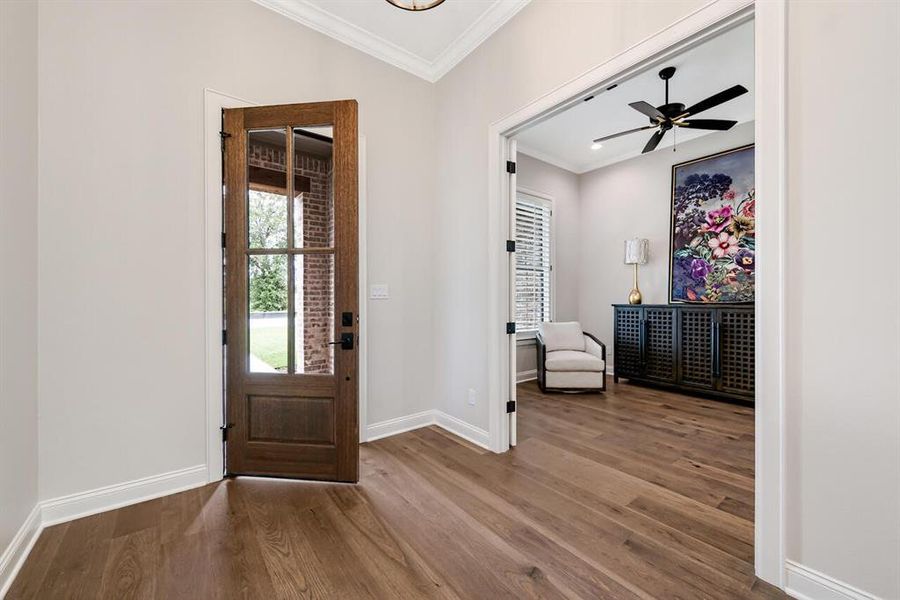 Entrance foyer with wood finished floors, crown molding, and ceiling fan Entrance foyer with wood finished floors, crown molding, and ceiling fan