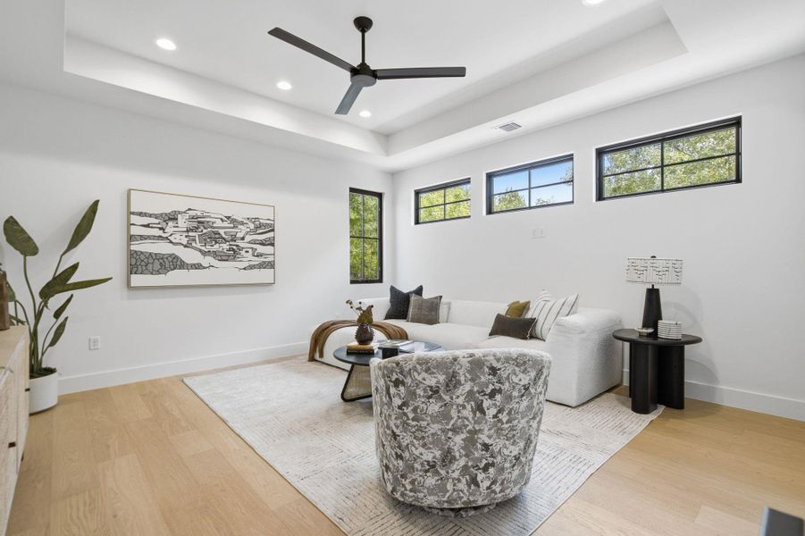 High recessed ceilings and wide plank wood flooring elevate this contemporary living space.